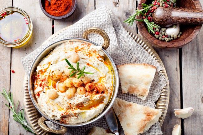 Hummus to pasta z ciecierzycy, oliwy, czosnku i tahini, którą można jeść ze świeżymi warzywami
