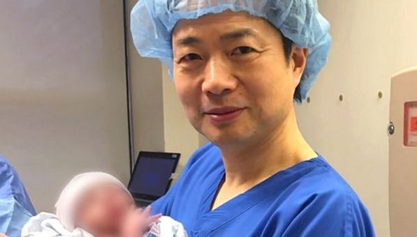 Dr John Zhang trzymający noworodka z DNA trzech osób