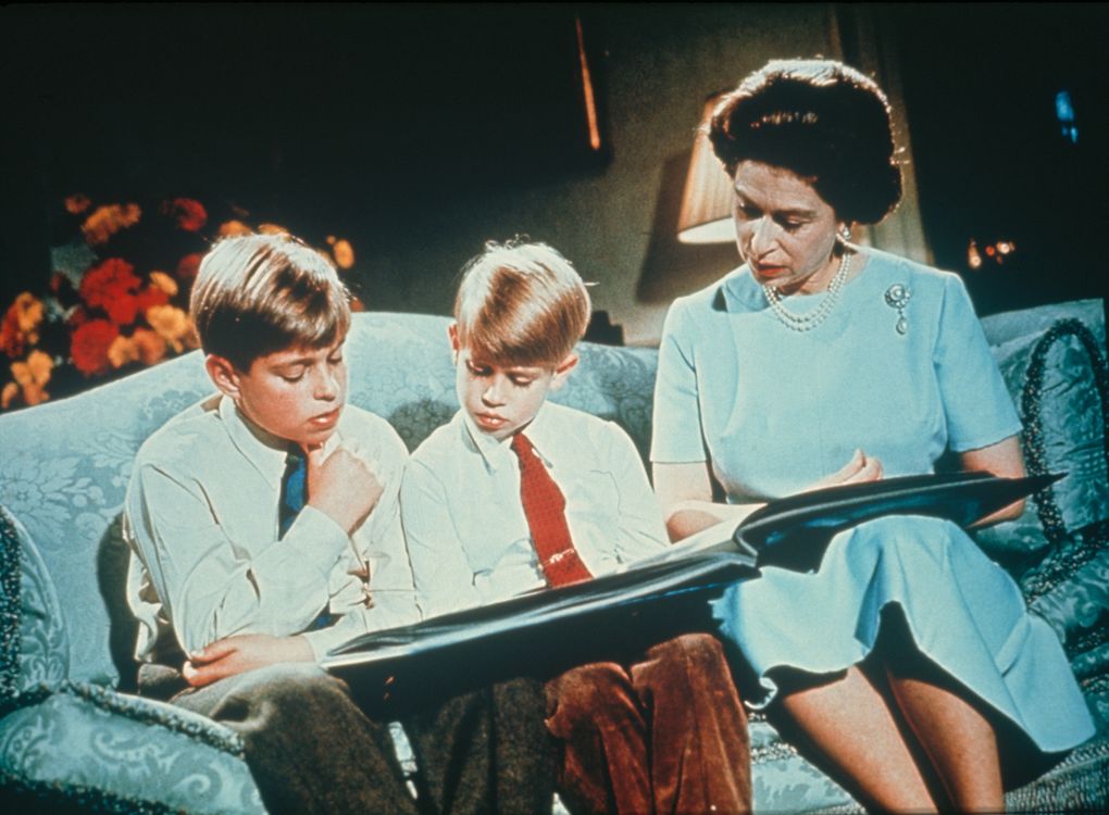 Queen Elizabeth II looking at a photograph album with her sons Prince Andrew (left) and Prince Edward, December 1971