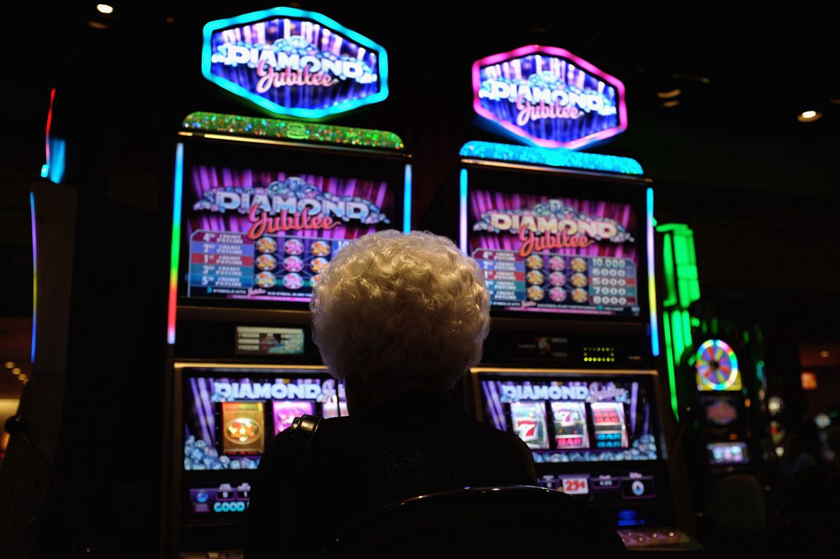 Starsza kobieta gra na automatach w kasynie w Atlantic City, New Jersey, USA