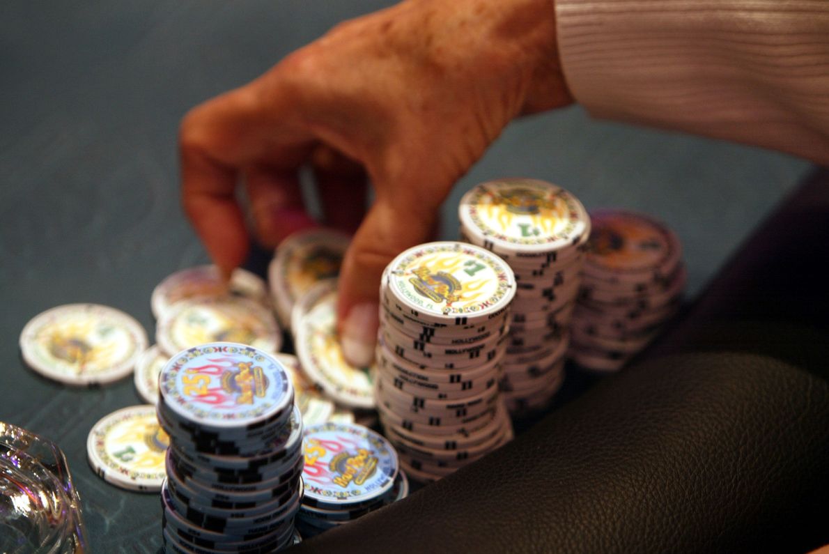 Gracz szykuje się do położenia żetonów pokerowych na stole