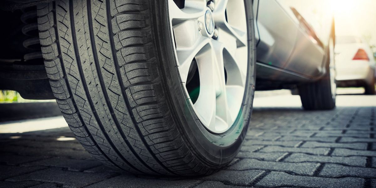 Car tire close up, parked car low angle shotCar all-season tire close up, parked car. Low angle shot, wheel auto with aluminum rim concepttire, car, road, wheel, auto, rubber, aluminum, rim, trip, journey, parking, blur, velocity, automobile, tyre, all, automotive, season, movement, texture, track, travel, line, vertical, paving, groove, low, angle, suv, summer, heat, black, sunshine, street, closeup, morning, city, drive, life, silver, perspective, scene, sun, sunlight, sunrise, sunset, transport, transportation, urban, wires