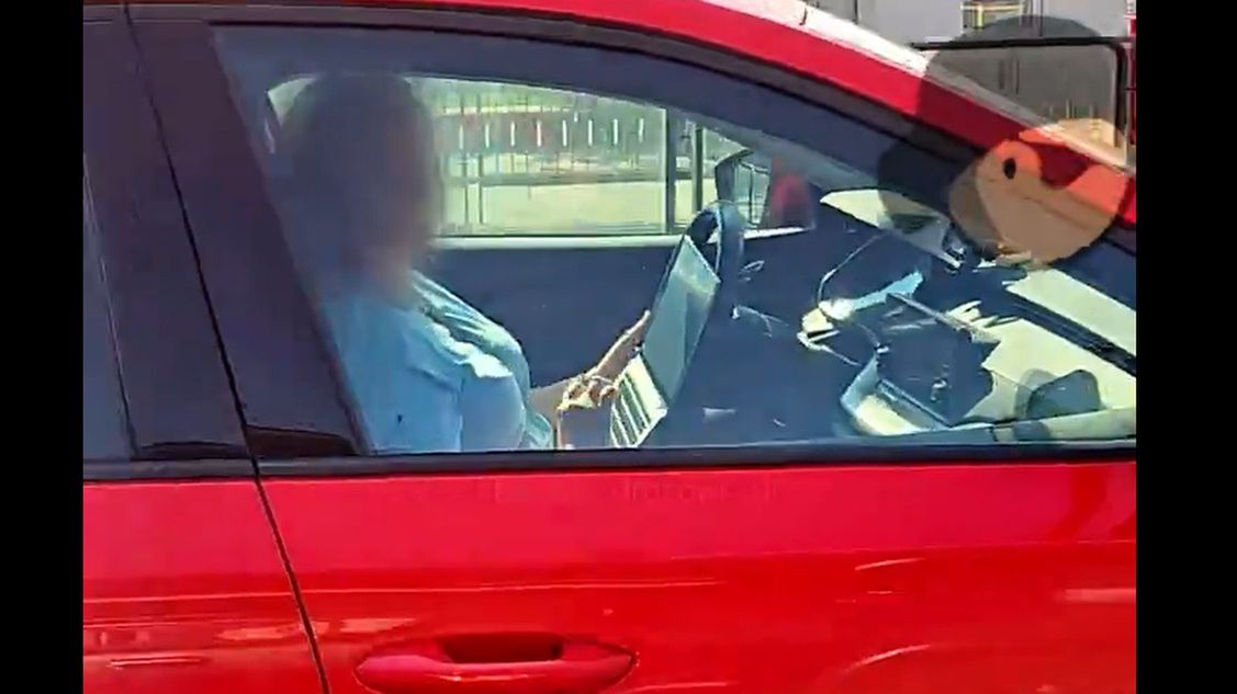 kobieta przegląda laptopa jadąc autem