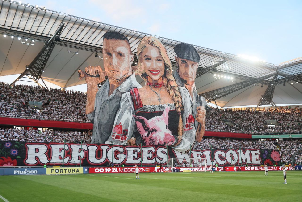 “Welcome, refugees.” However take an in depth take a look at the Legia’s cowl.