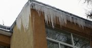 Zwisające sople i śnieg na dachach