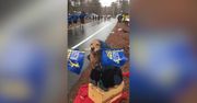 Czworonożny kibic na trasie maratonu. Uroczy golden retriever z flagą w pysku zagrzewał biegaczy do walki