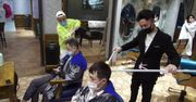 Mycie i strzyżenie włosów z bezpiecznej odległości. Fryzjerzy w Chinach korzystają z maszynek i grzebieni na metrowych kijach