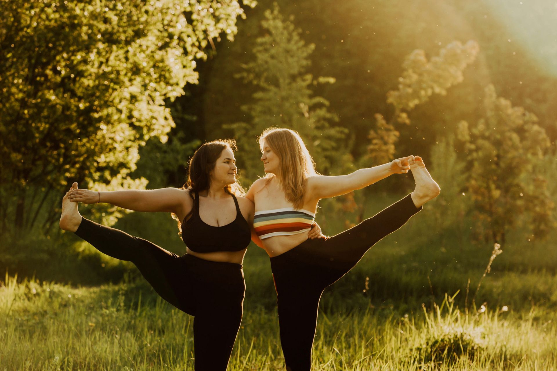 Two women with long hair doing yoga on a sunny day.Two beautiful women with long hair doing yoga in nature on a sunny summer day. Body positive, sports for women and couple, harmony, asana, healthy lifestyle, inspiring look, self-love and wellness.yoga, woman, fitness, asana, body positive, female, girl, body, health, healthy, lifestyle, people, relaxation, young, adult, beautiful, exercise, meditation, nature, pose, sport, fit, outdoor, park, summer, sunset, care, hands, slim, trees, beauty, concentration, balance, energy, relax, activity, athlete, brunette, clothing, pilates, practicing, sun rays, wellness, plus size, weight, friend, couple, together, curvy, long hair