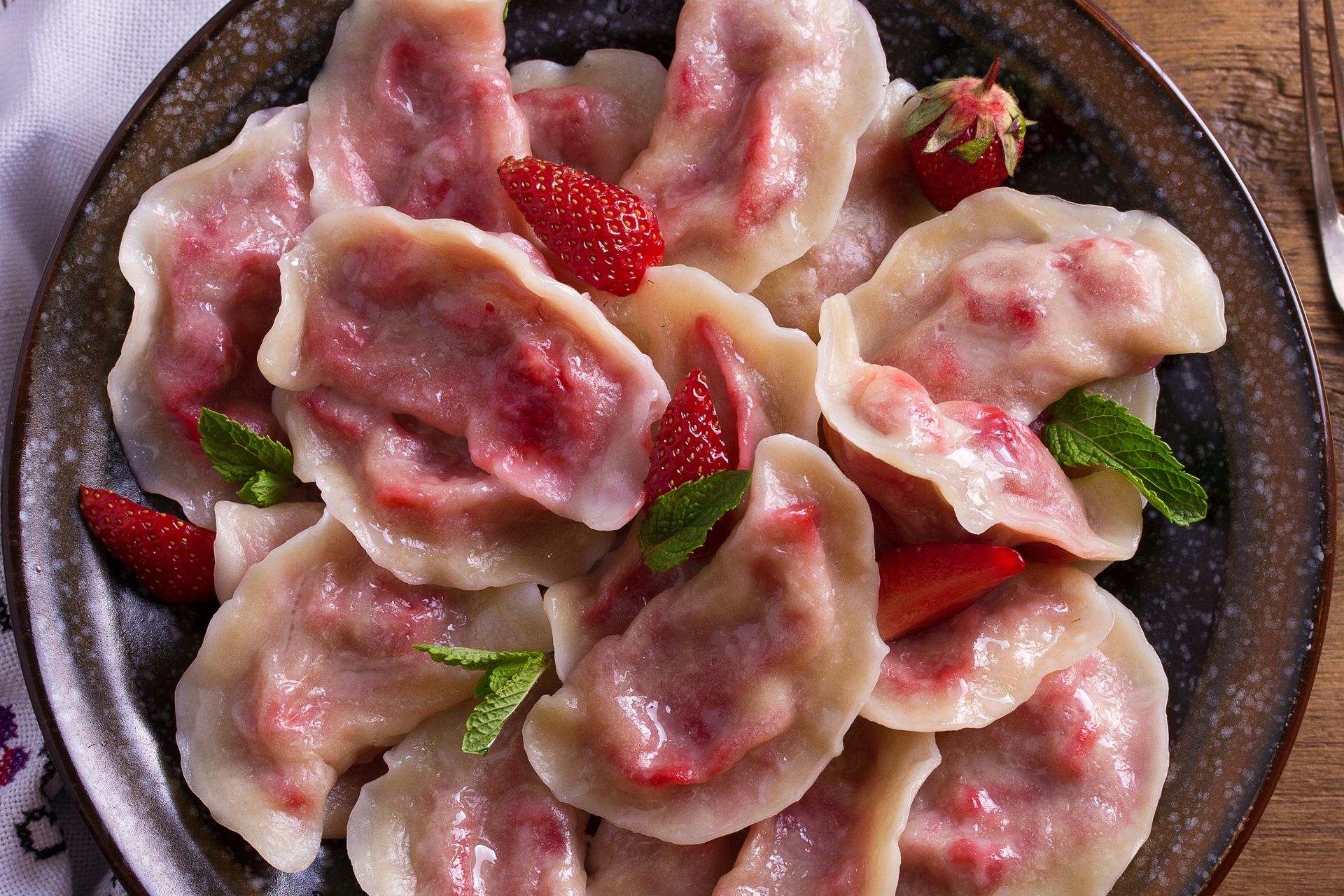 Pierogi z truskawkami wychodzą miękkie i delikatne, ale nie rozpadają się. Tylko dodaj odrobinę do ciasta