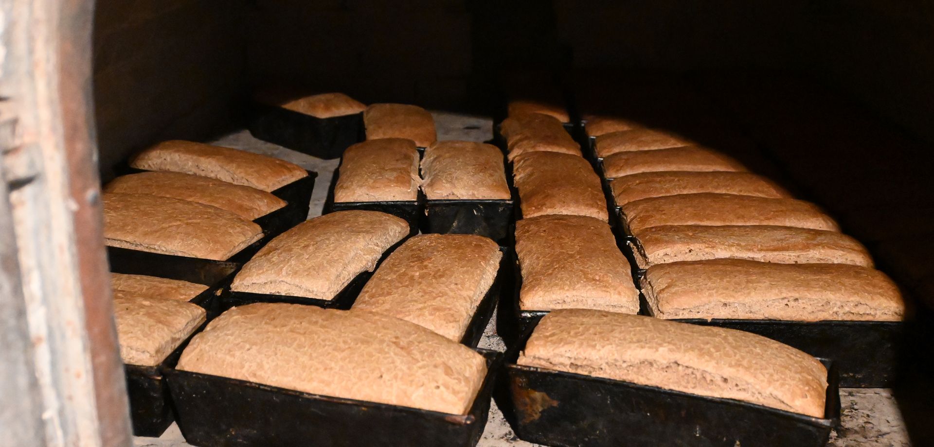 Bochenki chleba wewnątrz pieca opalanego żywym drewnem