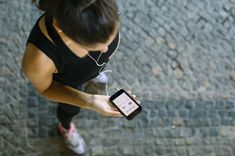 Kobieta przegląda aplikację do biegania (zdjęcie ilustracyjne)