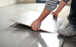 mężczyzna układa płytki na podłodze