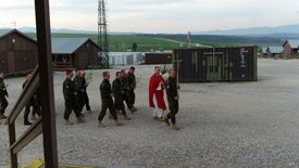 Kapelan wojskowy razem z żołnierzami na misji zagranicznej.
