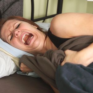 kobieta w łóżku krzyczy