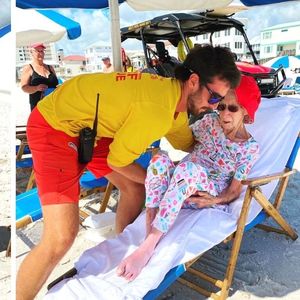 Ratownicy noszą seniorkę na rękach i umożliwiają jej spędzenie wakacji na plaży