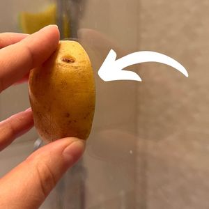 ręka pocierająca ziemniakiem szybę pod prysznicem