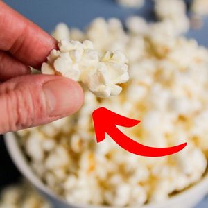 trik na puszysty popcorn - ręka wyjmująca kawałek popcornu z miski