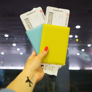 ręka trzymająca bilety lotnicze na lotnisku