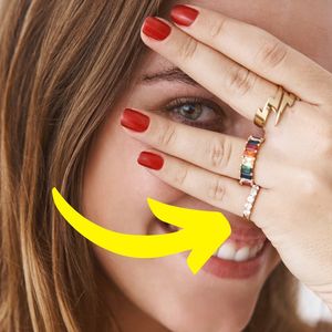 kobieta z pierścionkiem na małym palcu patrzy przez palce