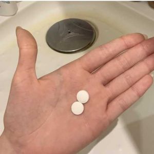 tabletki aspiryny na dłoni w łazience