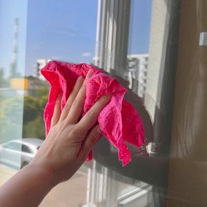 ręka myjąca okno szmatką