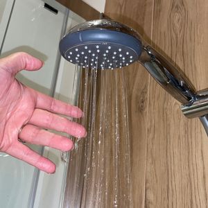 ręka pod uruchomionym prysznicem
