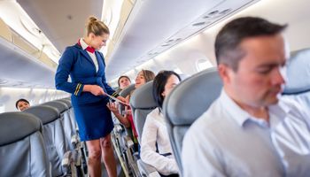 stewardesa rozmawia z pasażerką w samolocie