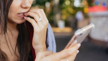zmartwiona kobieta patrzy na telefon