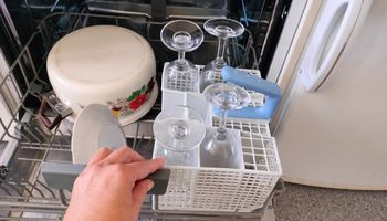 kieliszki w koszyku na sztućce w zmywarce
