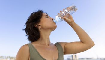 kobieta piję wodę z butelki na zewnątrz