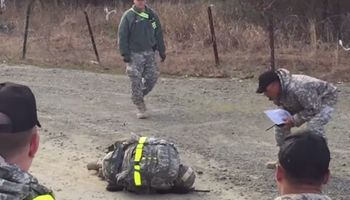 Kobieta należąca do armii pada na ziemię. Obserwuj uważnie reakcję żołnierzy stojących wokół niej