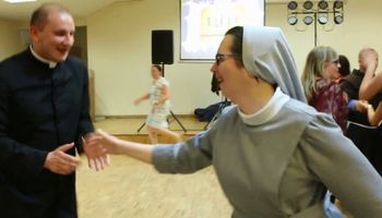 Rozbawiony młody ksiądz tańczy z zakonnicą. Niektórzy są obruszeni zachowaniem duchownego