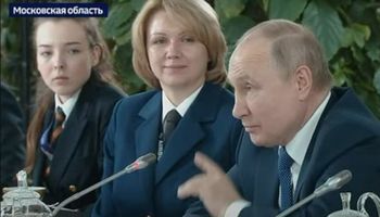 Ręka Putina przenika mikrofon