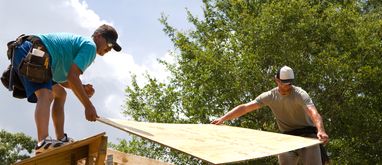 pracownicy w trakcie wykonywania drewnianej więźby dachowej