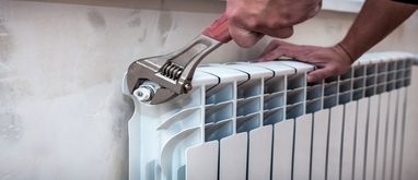 Człowiek odpowietrzający kaloryfer