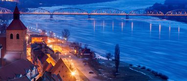 Widok z lotu ptaka na Wisłę, most i oświetloną po zmroku ulicę