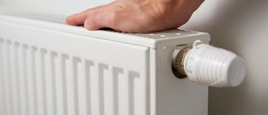 ręka na kaloryferze, oczekiwanie na sezon grzewczy