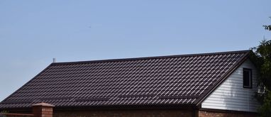 Dach domu pokryty blachą trapezową w brązowym kolorze
