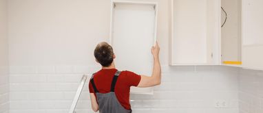 Pracownik montujący kuchnię na wymiar