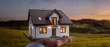 Makieta domu jednorodzinnego na dłoni wybór działki budowlanej