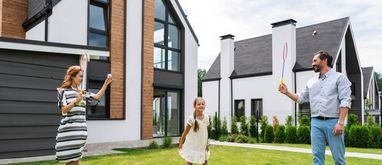 Rodzina bawi się przed domem na trawie