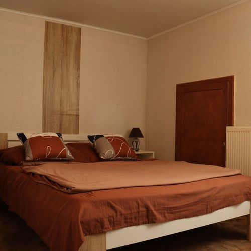 Pokoj s manželskou postelí s výhledem do zahrady v podkroví
