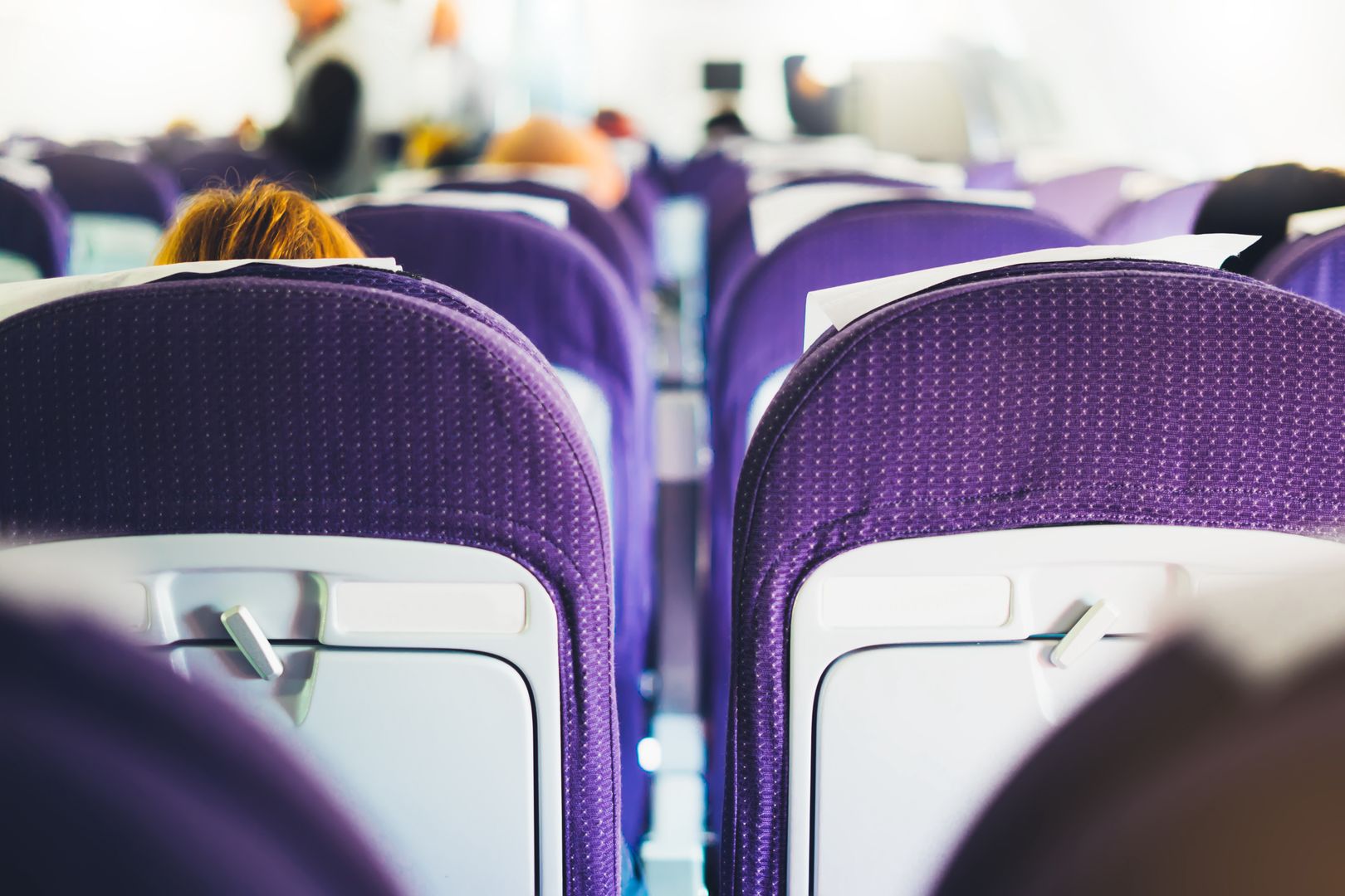 Why do flight attendants sit on their hands?