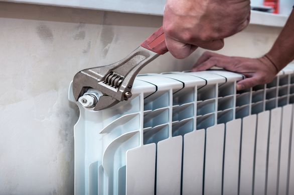 Człowiek odpowietrzający kaloryfer