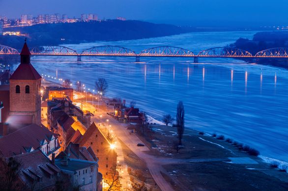 Widok z lotu ptaka na Wisłę, most i oświetloną po zmroku ulicę