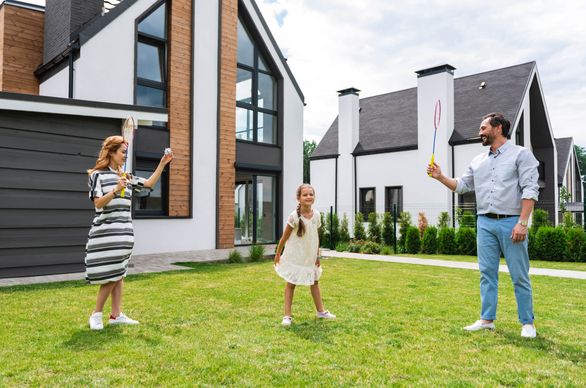 Rodzina bawi się przed domem na trawie