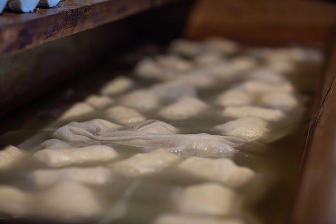 Bacówka w Białce Tatrzańskiej. Zanurzone oscypki w drewnianym pojemniku.  