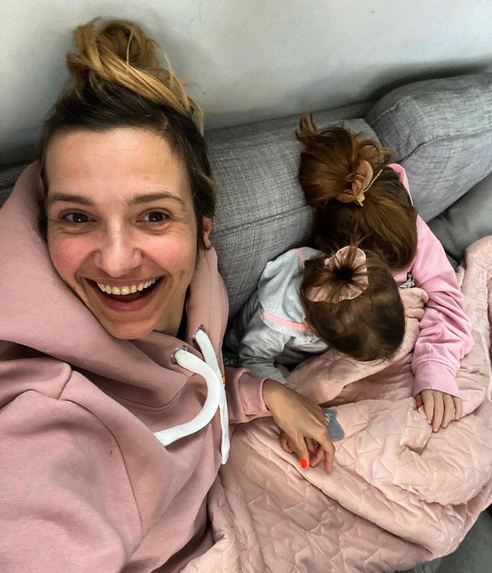 Joanna Koroniewska w salonie odpoczywa na kanapie z córkami