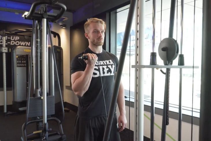 Mateusz Matłosz, trener personalny i ekspert Fabryki Siły, demonstruje ćwiczenie na biceps