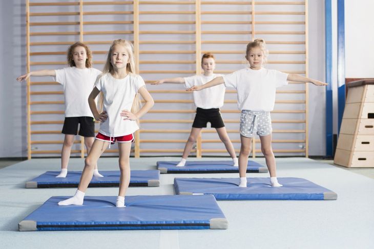 Dzieci ćwiczące na sali gimnastycznej